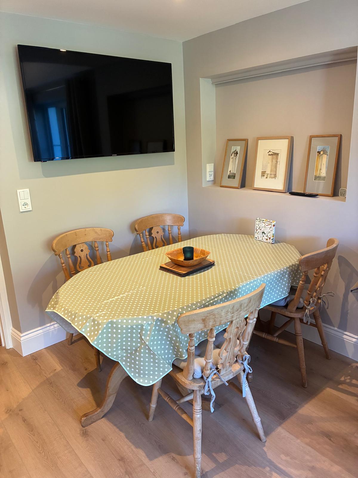 Gretl dining area with an oval table and four wooden chairs